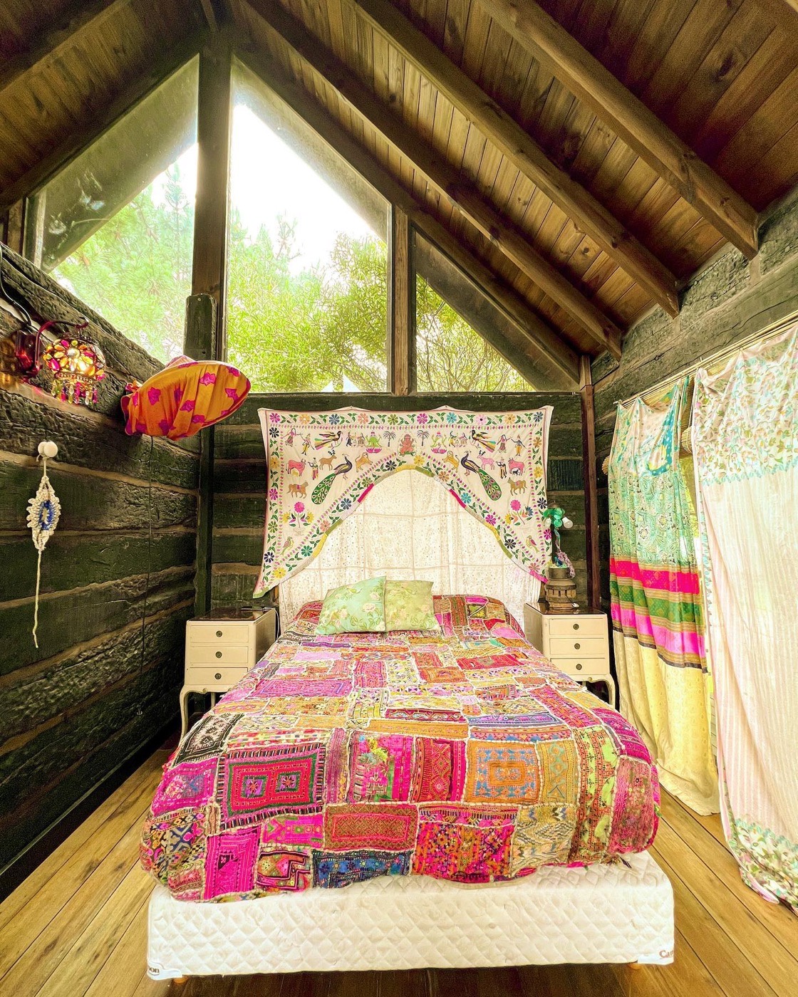 Cuarto con tapiz bordado y ventanal al bosque